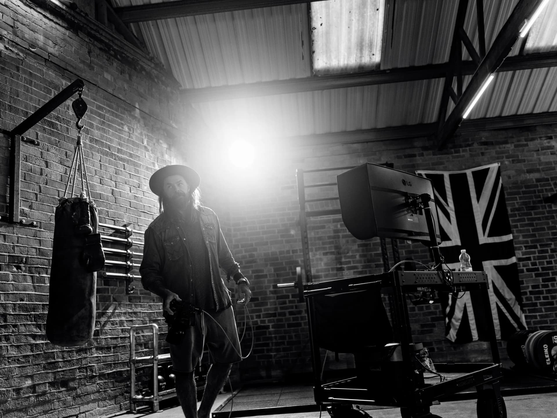 Christopher Bailey silhouetted in his studio with dramatic backlighting