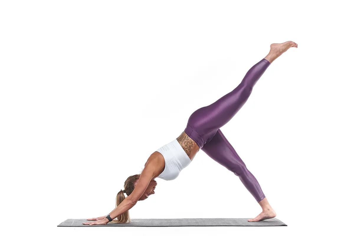 Three-legged downward dog yoga pose in studio photography session