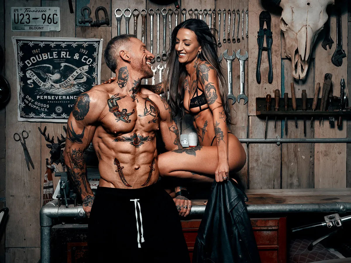 Fitness couple laughing together in styled workshop setting