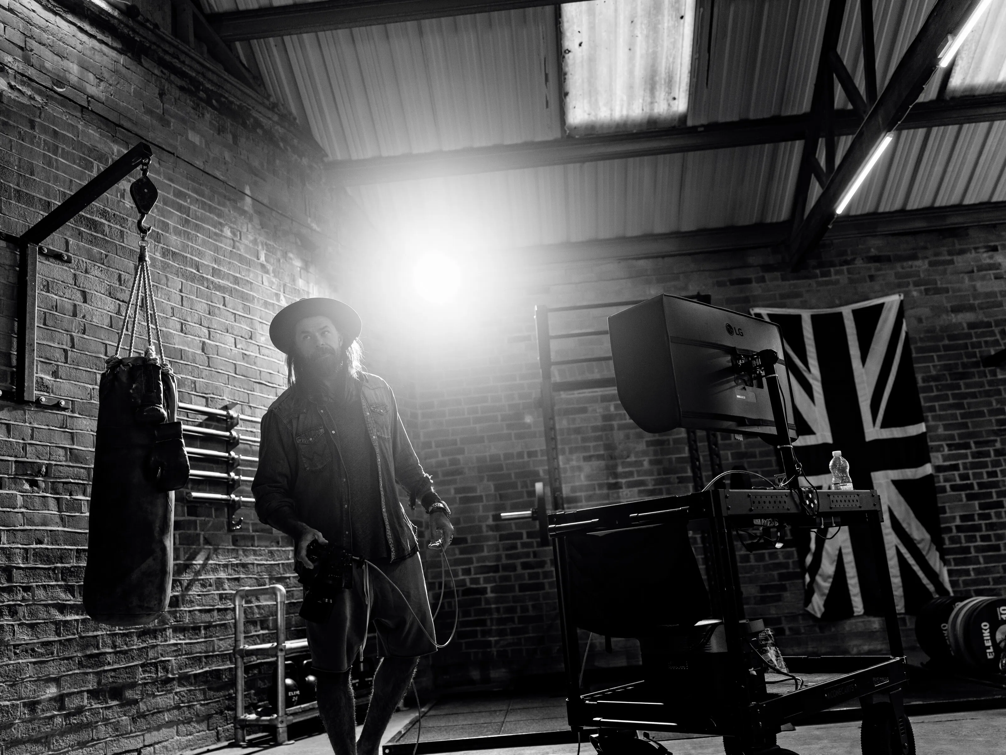 Christopher Bailey silhouetted in his studio with dramatic backlighting